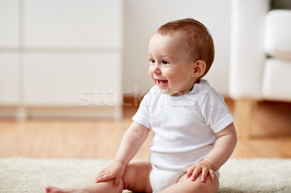 happy baby boy or girl sitting on floor at home Stock photo © dolgachov