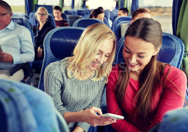 happy young women in travel bus with smartphone Stock photo © dolgachov