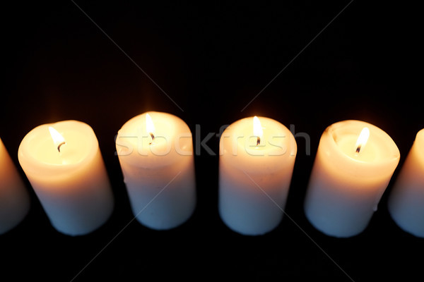 candles burning in darkness over black background Stock photo © dolgachov