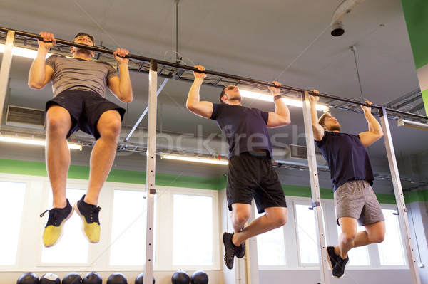 group of young men doing pull-ups in gym Stock photo © dolgachov