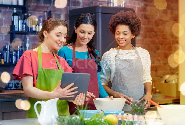 happy women with tablet pc cooking in kitchen Stock photo © dolgachov