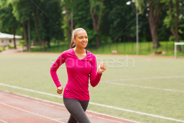 smiling woman running on track outdoors Stock photo © dolgachov