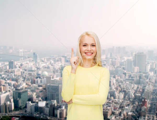Glimlachende vrouw wijzend vinger omhoog advertentie aantrekkelijk Stockfoto © dolgachov