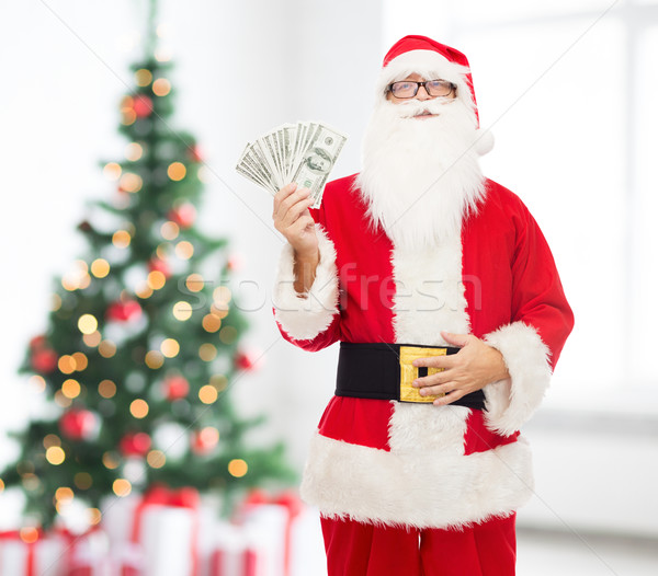 man in costume of santa claus with dollar money Stock photo © dolgachov