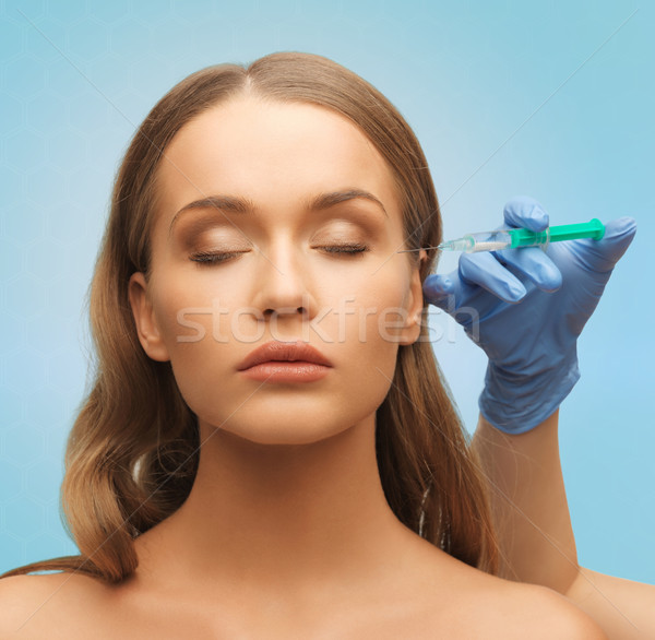 beautiful woman face and hand with syringe Stock photo © dolgachov