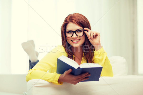 Zâmbitor adolescent lectură carte şedinţei canapea Imagine de stoc © dolgachov