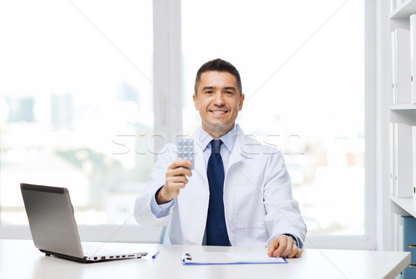 smiling doctor with tablets and laptop in office Stock photo © dolgachov