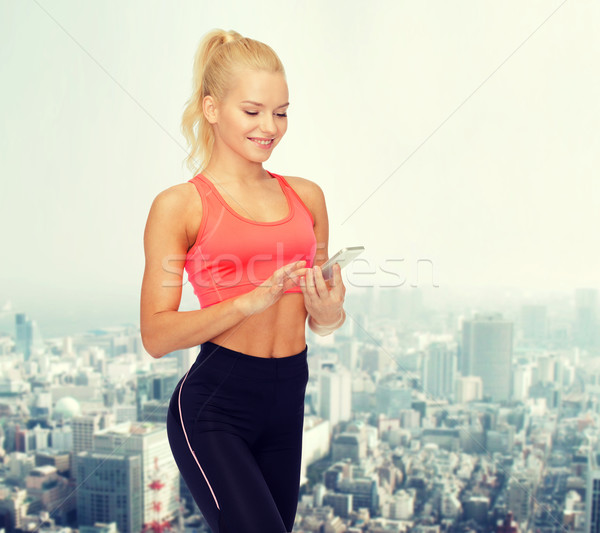Stock photo: smiling sporty woman with smartphone