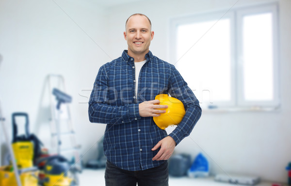 smiling man holding helmet over room background Stock photo © dolgachov