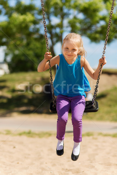 happy little girl swinging on swing at playground Stock photo © dolgachov