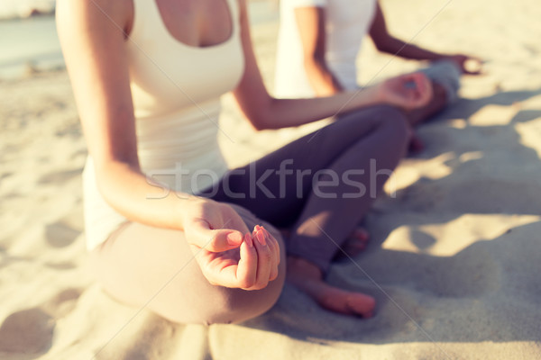 close up of couple making yoga exercises outdoors Stock photo © dolgachov