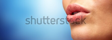 close up of young woman lips over blue Stock photo © dolgachov