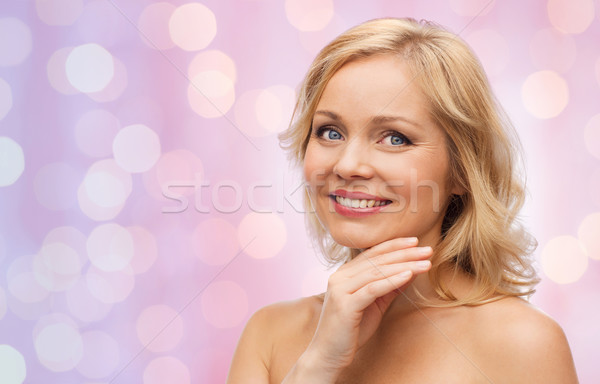 Stock photo: smiling woman with bare shoulders touching face