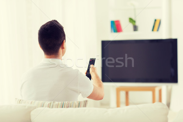 man watching tv and changing channels at home Stock photo © dolgachov