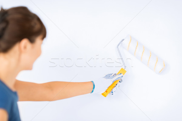 woman with roller and paint colouring the wall Stock photo © dolgachov