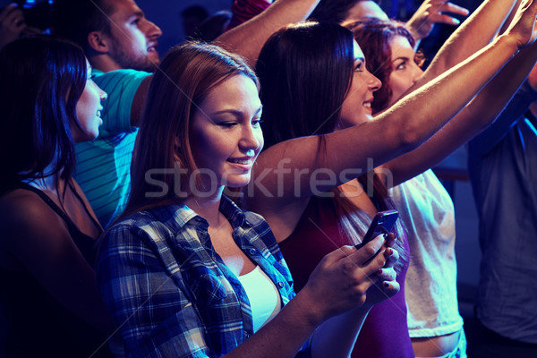 woman with smartphone texting message at concert Stock photo © dolgachov