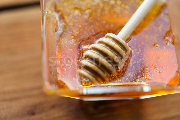 close up of honey in glass bowl and dipper Stock photo © dolgachov