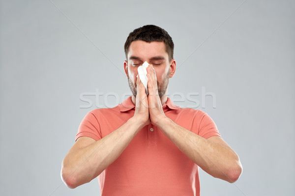 sick man with paper napkin blowing nose Stock photo © dolgachov