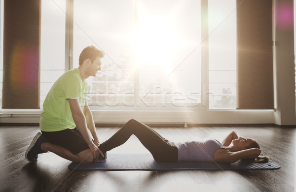 woman with personal trainer doing sit ups in gym Stock photo © dolgachov