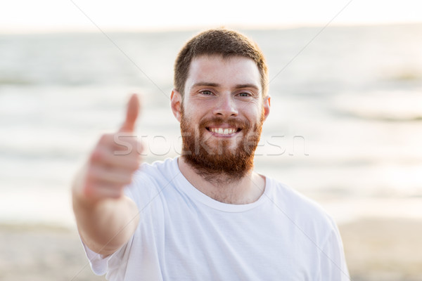 happy smiling young man on beach Stock photo © dolgachov