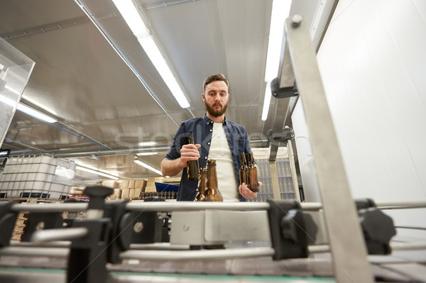 men with bottles on conveyor at craft beer brewery Stock photo © dolgachov