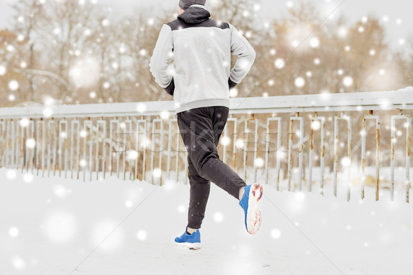 man running along snow covered winter bridge road Stock photo © dolgachov