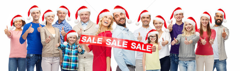 Stock photo: people in santa hats with sale sign at christmas