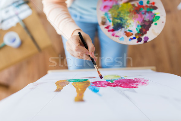 artist with palette and brush painting at studio Stock photo © dolgachov