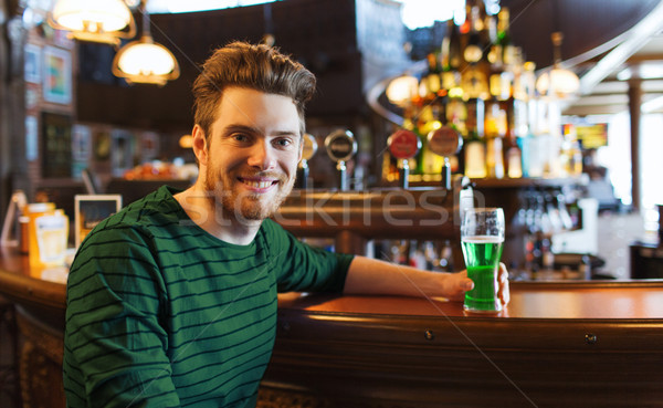 man drinking green beer at bar or pub Stock photo © dolgachov