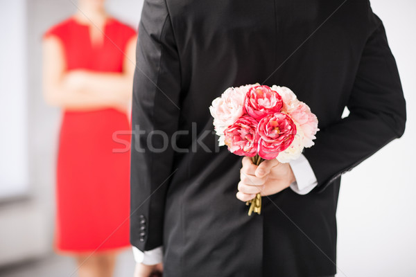 Mann versteckt Bouquet Blumen hinter zurück Stock foto © dolgachov