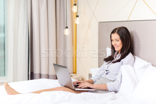 happy businesswoman with laptop in hotel room Stock photo © dolgachov