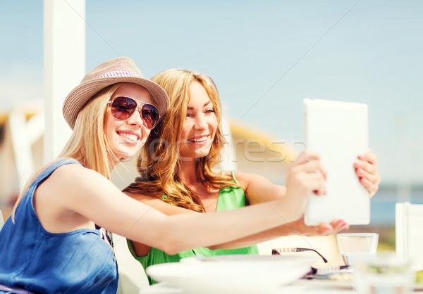 girls taking photo in cafe on the beach Stock photo © dolgachov