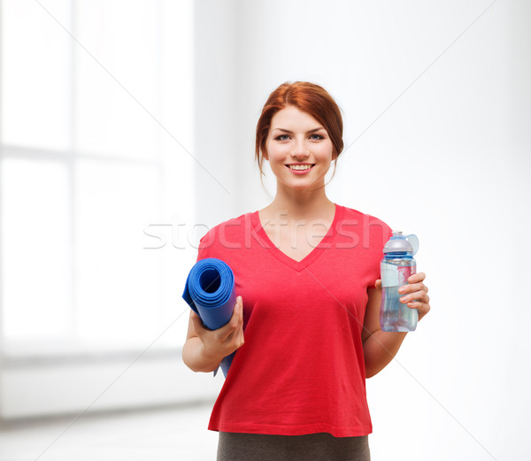 smiling girl with bottle of water after exercising Stock photo © dolgachov