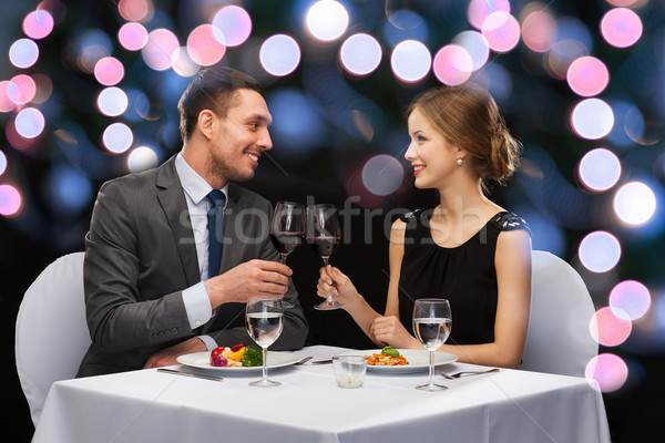 smiling couple eating main course at restaurant Stock photo © dolgachov