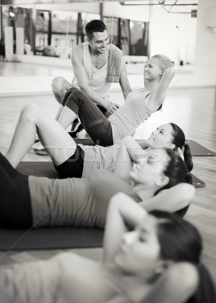group of smiling women doing sit ups in the gym Stock photo © dolgachov