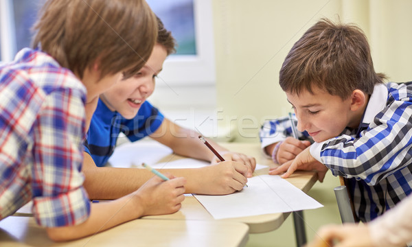 group of schoolboys writing or drawing at school Stock photo © dolgachov