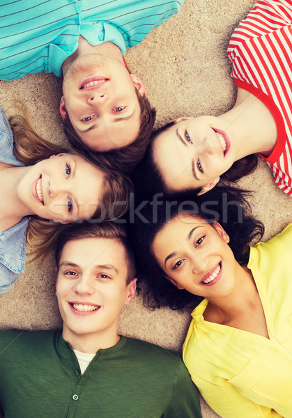 group of smiling people lying down on floor Stock photo © dolgachov