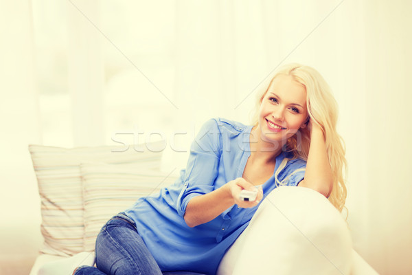 smiling young girl with tv remote control at home Stock photo © dolgachov