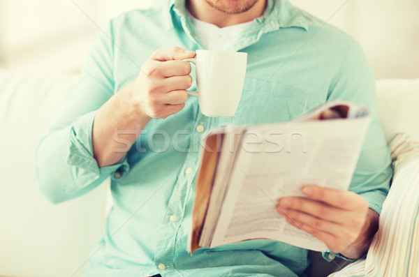 Közelkép férfi magazin iszik csésze otthon Stock fotó © dolgachov