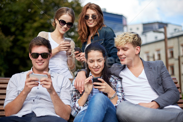 Studenţi adolescenti smartphone-uri campus vară tehnologie Imagine de stoc © dolgachov