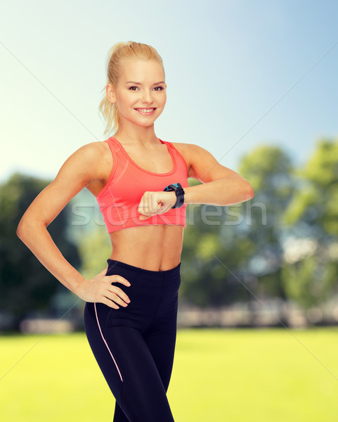 Mosolygó nő szívritmus monitor kéz fitnessz technológia Stock fotó © dolgachov