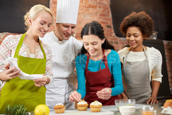 happy women and chef cook baking in kitchen Stock photo © dolgachov