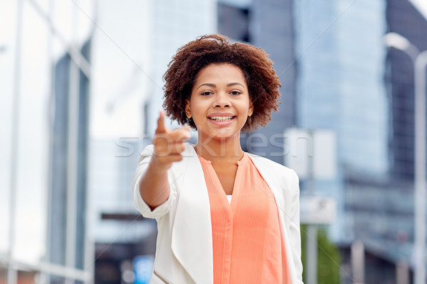 happy african businesswoman pointing finger on you Stock photo © dolgachov