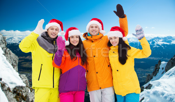 happy friends in santa hats and ski suits outdoors Stock photo © dolgachov