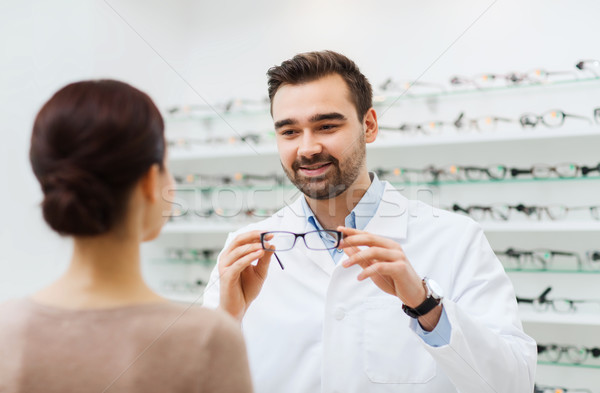 Vrouw opticien tonen bril optica store Stockfoto © dolgachov