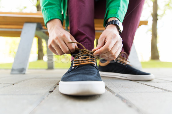 close up of male hands tying shoe laces on street Stock photo © dolgachov