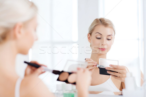 woman with makeup brush and foundation at bathroom Stock photo © dolgachov