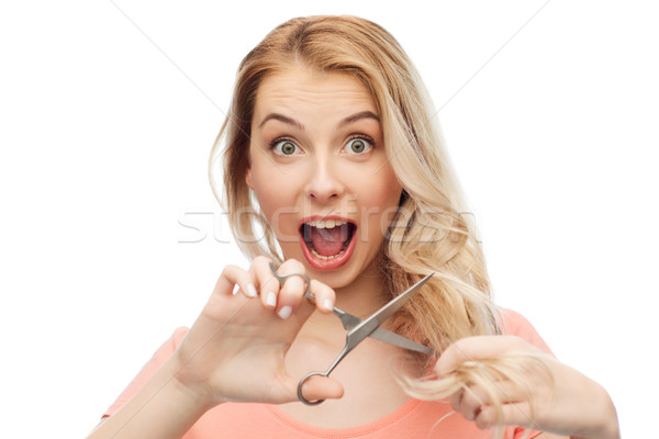 woman with scissors cutting ends of her hair Stock photo © dolgachov