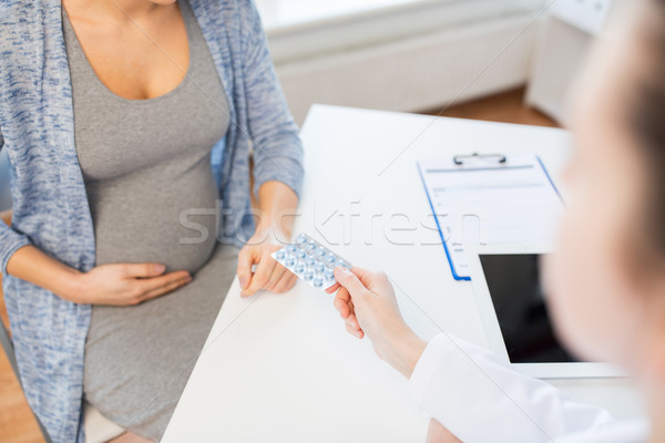 close up of doctor giving pills to pregnant woman Stock photo © dolgachov
