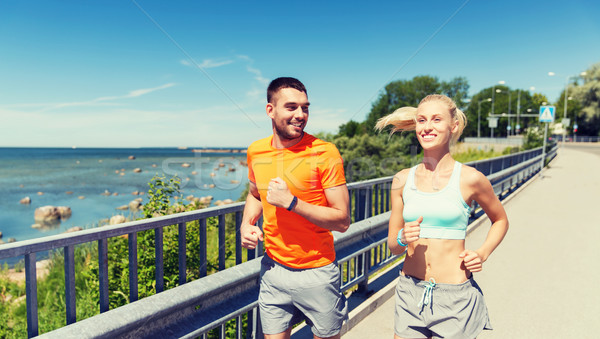 smiling couple running at summer seaside Stock photo © dolgachov